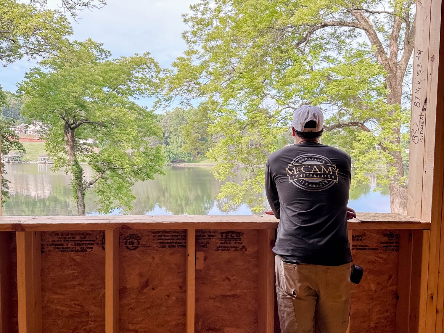 Todd looking out over the lake from a framed-in porch on a custom home build